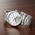 Automatic wristwatch with exhibition caseback on dark wooden surface