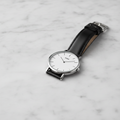 Slim quartz watch on light marble surface